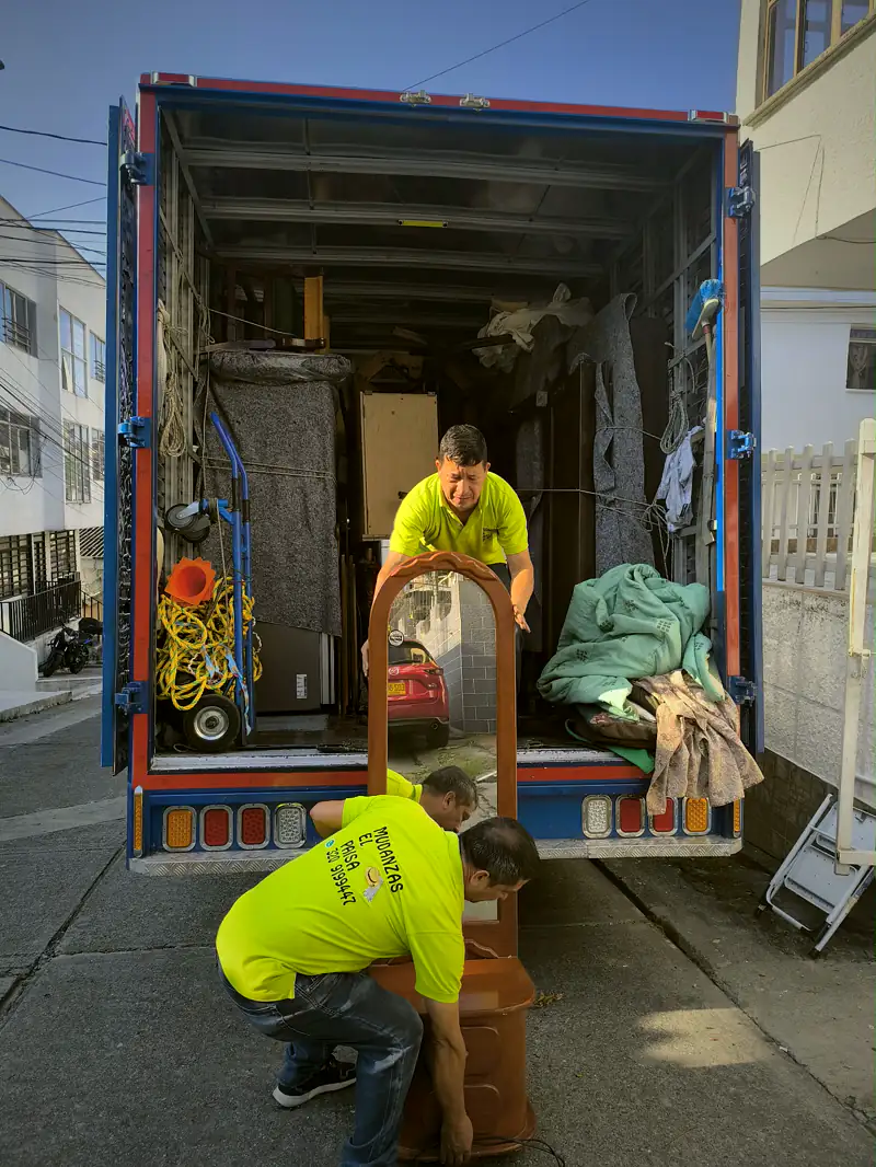 Operarios acomodando muebles dentro del furgón